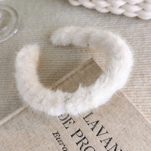 Detailed macro view of plush white faux fur headband texture on a vintage book