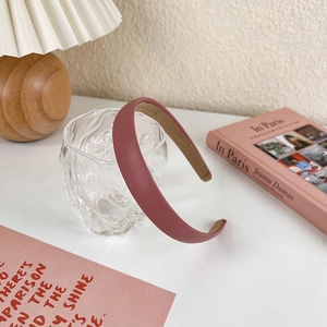 Detail of pink leather headband with soft texture against a warm lifestyle backdrop