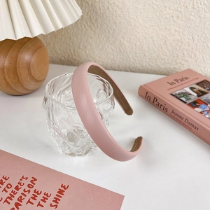 Detail of pink padded sponge headband with matte faux leather texture and non-slip lining