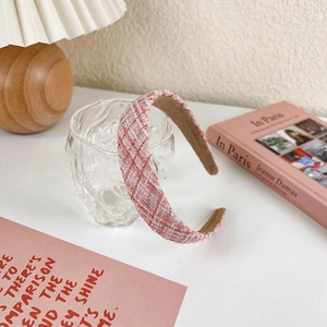 Detail of pink and white tweed headband with silver glitter on a decorative glass