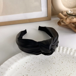 Close-up of black PU leather knotted headband featuring a vintage minimalist texture