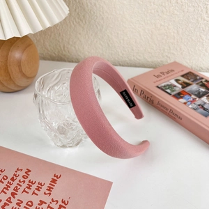 Detail view of pink padded headband with handmade label on a decorative setup