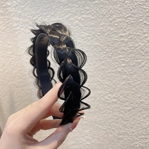 Close-up of black fishtail braid headband with anti-slip teeth and textured hair fibers