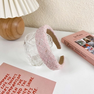 Detail of pink tweed headband with gold metallic threads on a cozy lifestyle background