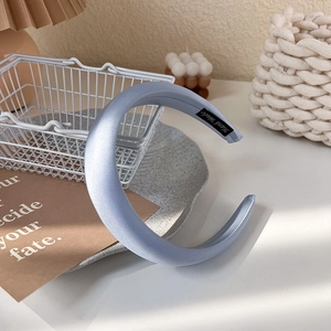 Détail du serre-tête rembourré en satin bleu clair avec étiquette Hand Made à l'intérieur