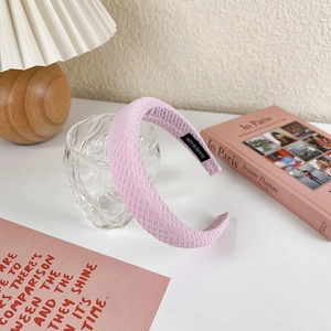 Detailed close-up of a pink padded headband showing fabric texture and hand made label