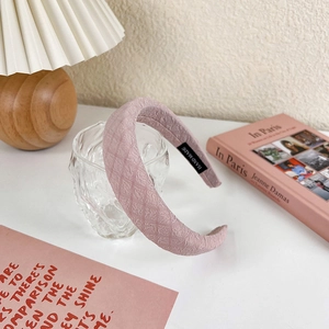 Detail of pink padded headband with diamond texture on a glass with warm background