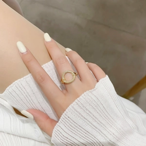 Detail of elegant gold-plated open ring with micro-paved rhinestones on a female finger