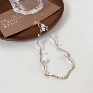 Detail view of pearl and zircon necklace featuring invisible fishline and lobster clasp