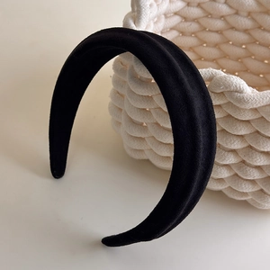 Close-up of black wide-brimmed padded headband with elegant matte suede texture