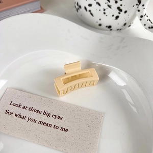 Close-up of a cream beige matte rectangular hollow hair claw clip in an aesthetic set