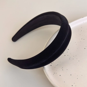 Detailed close-up of a padded black velvet headband showcasing fine fabric texture