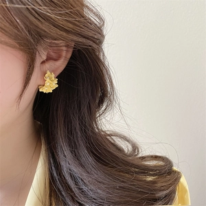 Elegant yellow flower earrings with white pearl center on model for spring fashion