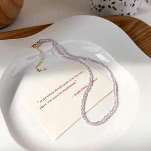 Dettaglio della collana di perline in cristallo lavanda con chiusura a moschettone d'oro