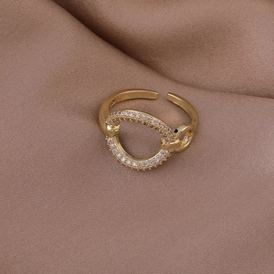 Close-up of golden adjustable ring featuring a pavé diamond circle and woven band details