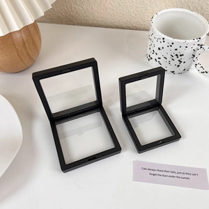 Black PE film jewelry suspension boxes in two sizes on a minimalist white desk