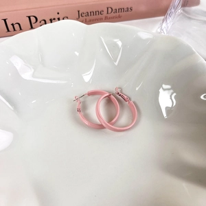 Nahaufnahme der rosa lackierten Creolen auf einem weißen Porzellanteller in Muschelform