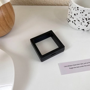 Detail shot of a black PE film floating jewelry box with PUSH button for dust-proof storage
