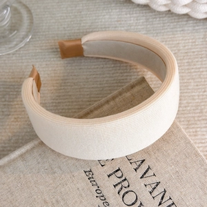 Close-up of the beige knitted fabric texture and brown ribbon ends on this wide headband