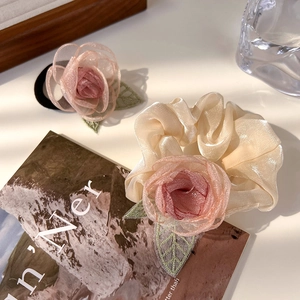 Detail van roze organza rozen haarelastiekje en scrunchie met groene bladborduring
