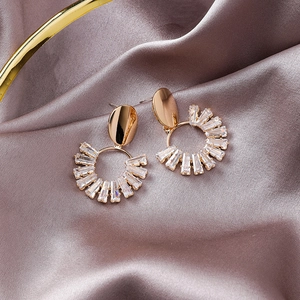 Detail of gold-plated oval stud earrings with radiant baguette-cut crystal zircons