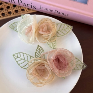 Detailweergave van organza bloem haaraccessoires in een vintage Franse schaal