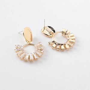Detail of gold geometric earrings with baguette-cut crystals and a fan-shaped design