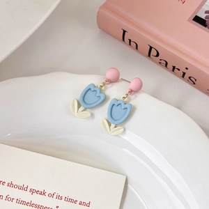 Dettaglio di orecchini a tulipano pastello con perni rosa e boccioli azzurro chiaro