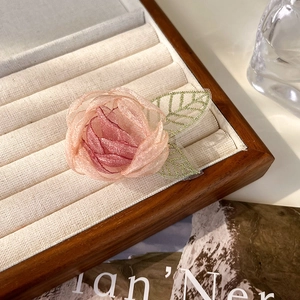 Detailopname van roze tule camelliabloem met goudgeaderde bladeren op beige dienblad