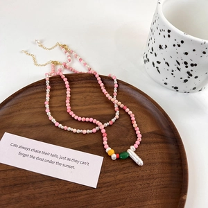 Detail of colorful handmade beaded necklaces with freshwater pearls on a wooden tray