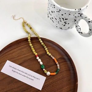 Detail of bohemian handmade beaded necklace with freshwater pearls and gold extension chain