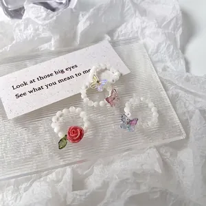 Lot de trois bagues en perles faites main avec breloques rose et papillons colorés