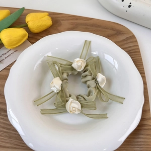 Detalle de coletero de malla verde claro con rosas crema y un lazo elegante de gasa