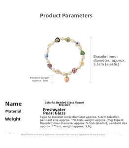 Détail de bracelet perlé avec perles d'eau douce, fleurs en verre et fraise