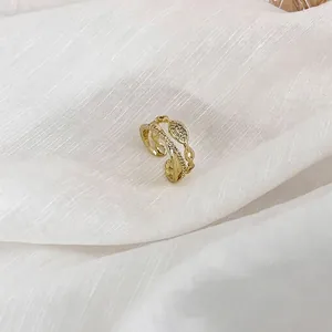 Bague croisée double couche en or avec zircons étincelants sur un tissu de soie blanche