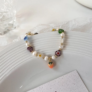 Vue détaillée d'un bracelet de perles d'eau douce avec un charmant pendentif fraise