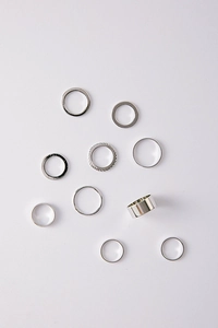 Flat lay of a 10-piece silver minimalist ring set featuring smooth and textured bands
