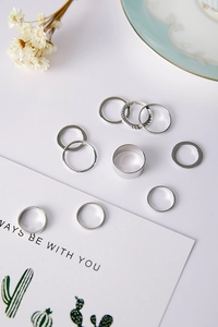 Detailed view of 9-piece minimalist silver ring set with varying textures and band widths
