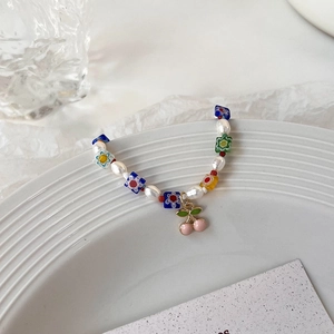 Détail du bracelet perlé avec perles d'eau douce et pendentif cerise rose