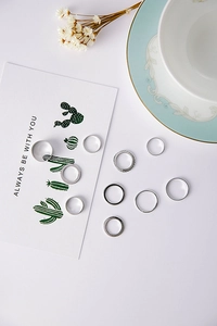 Set of 10 minimalist silver-tone rings with various textures and smooth bands on aesthetic decor