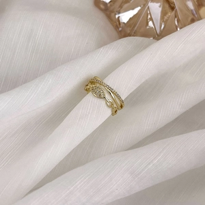 Gros plan d'une bague multicouche dorée avec pavé de zircons et cristal central ovale