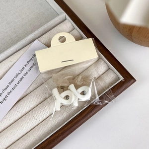 Detail view of mini matte hair claws in white and clear finish with card packaging