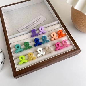 Set of 14 colorful mini matte cross hair clips organized in a wooden jewelry display box