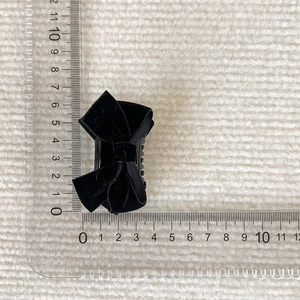 Detail of small black velvet bow hair clip with measurement scale showing 4.5cm size