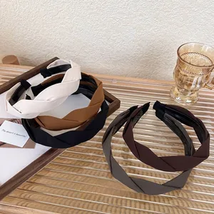 Detailed set of twist knotted fabric headbands in neutral earth tones on a wooden tray