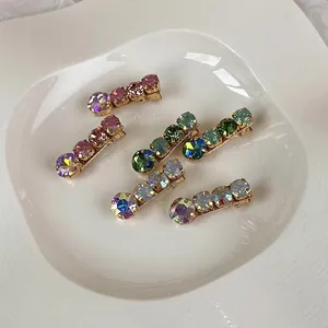 Sparkling rhinestone hair clips set in colorful summer cream tones on white ceramic tray