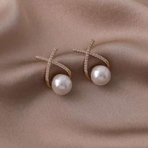 Vue détaillée de boucles d'oreilles perles style français avec cadre X doré et zircons