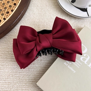 Detail of elegant wine red satin double-layer bow hair claw clip with black plastic grip