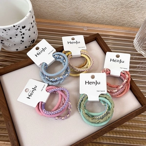 Detailed view of colorful braided elastic hair bands set in Morandi tones on a tray