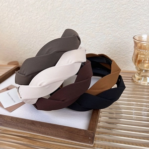 Close-up of five earth-toned twisted fabric headbands with anti-slip design